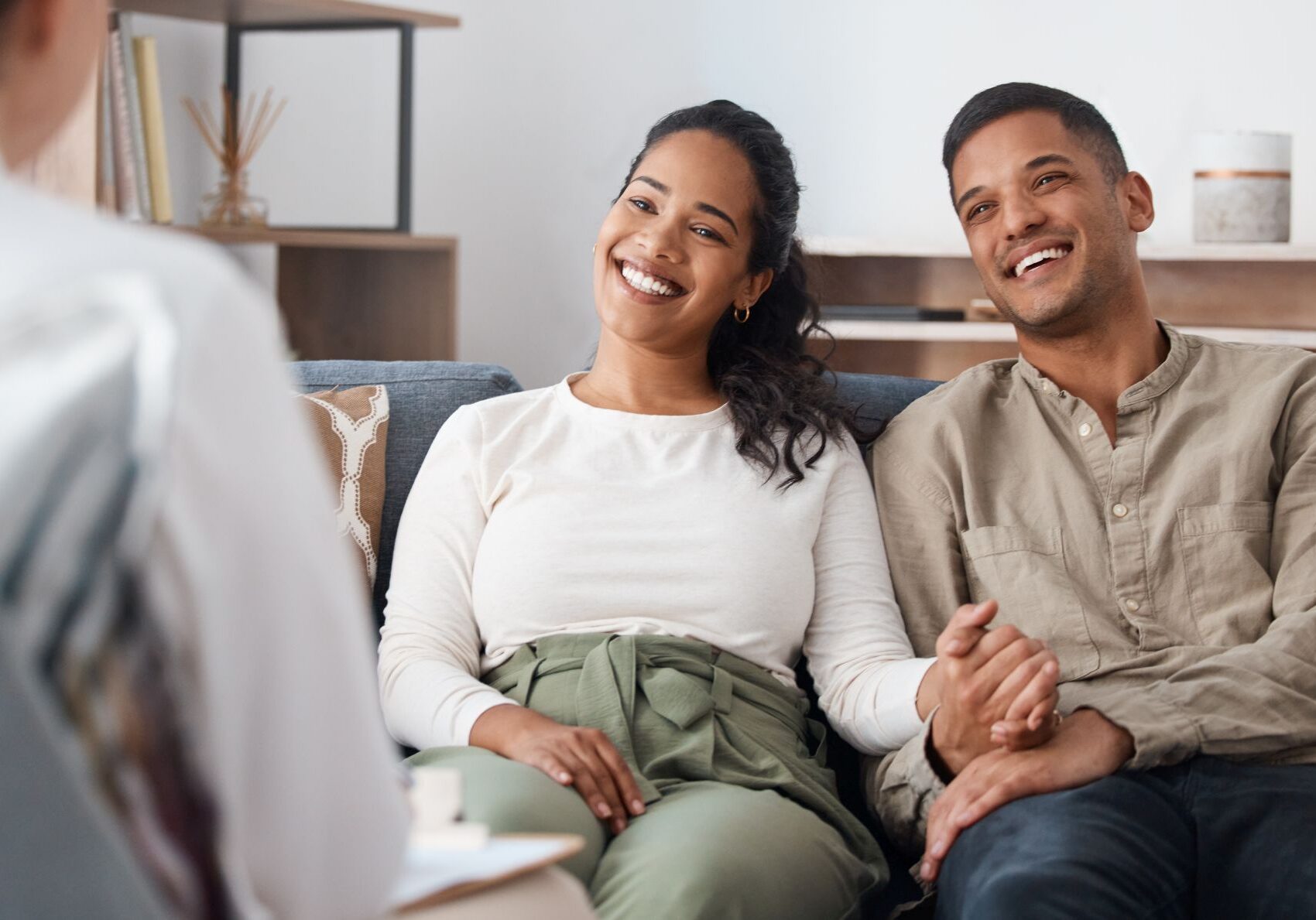 Shot of a happy young couple sitting together during a consultation with a psychologist.